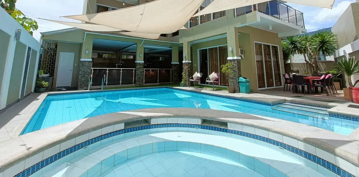 The adult pool and round jacuzzi by day