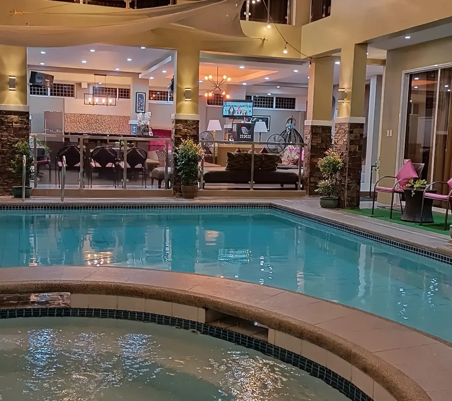 The pool and jacuzzi lit at night