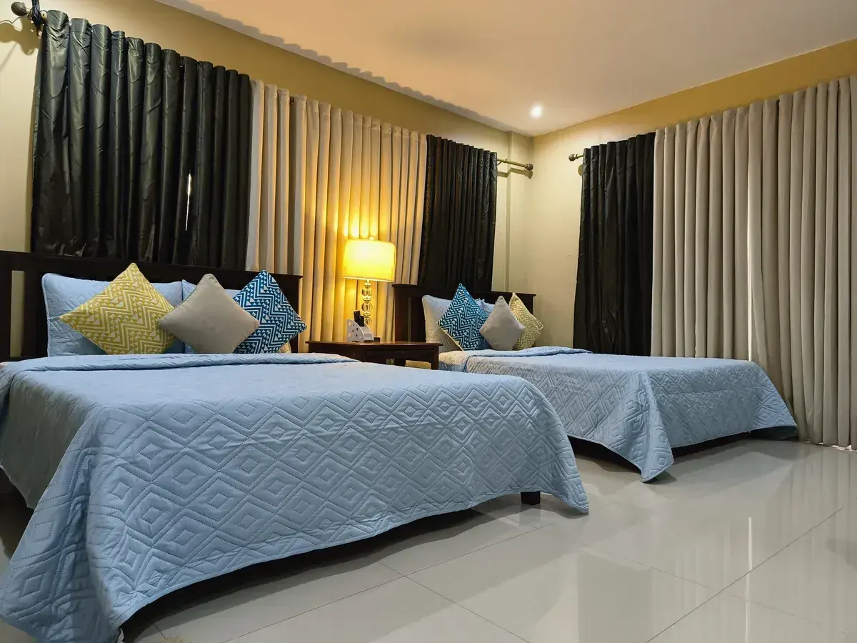 A bedroom with two beds and blackout curtains