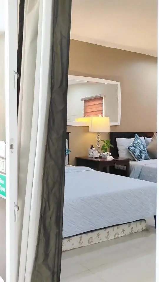 A bright room with a made bed and pillows