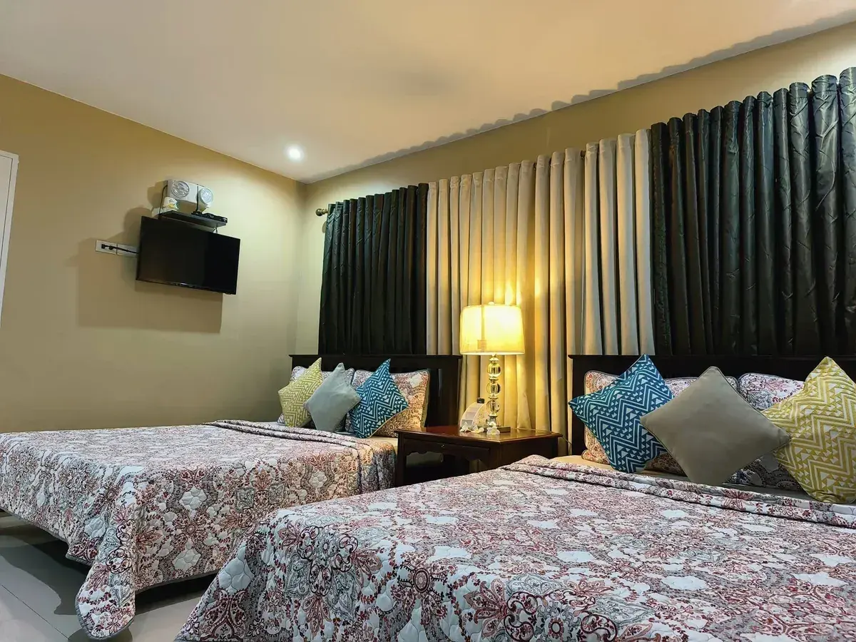 A bedroom with two beds and a wall TV