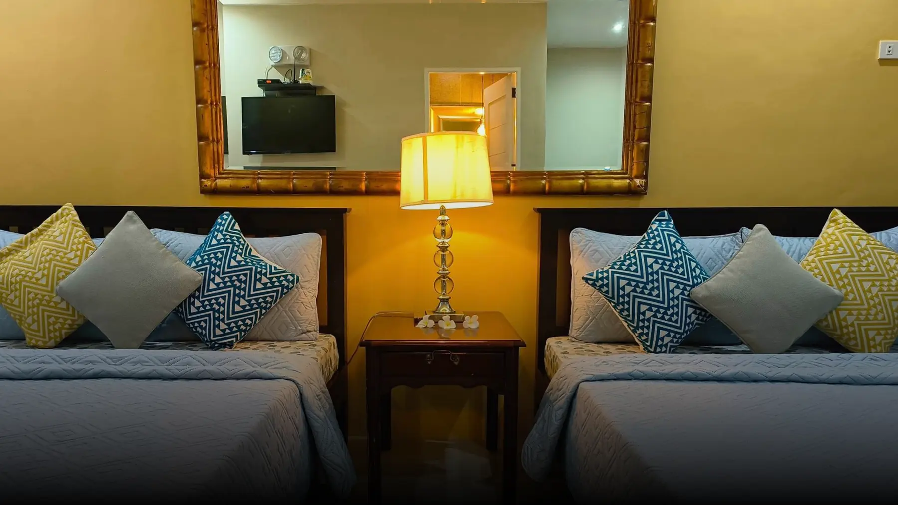 An air-conditioned room with two beds and bedside lamp