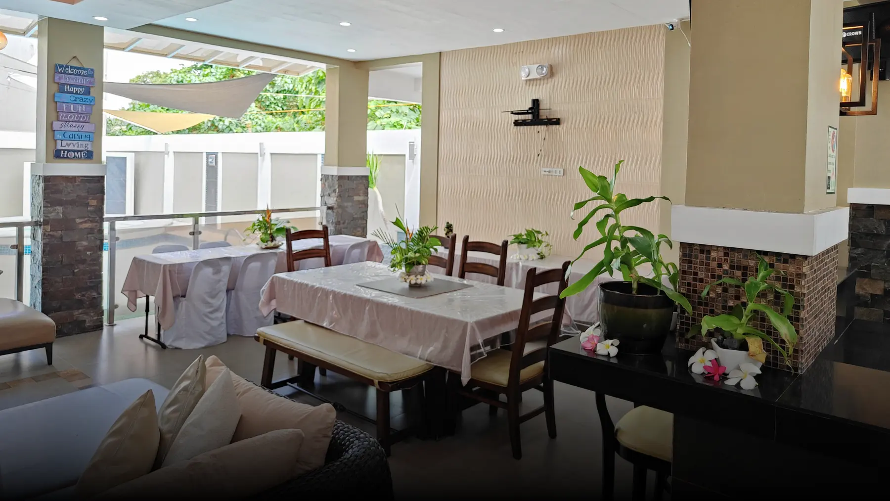 The covered veranda dining area with plants